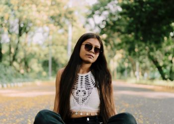 A woman sitting in the middle of a road