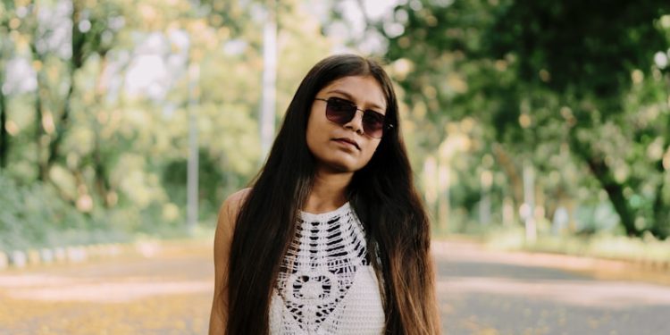 A woman sitting in the middle of a road
