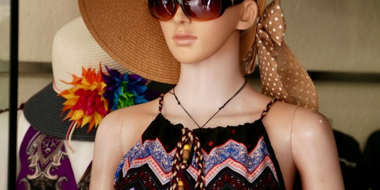woman in black and red sleeveless dress wearing brown sun hat and sunglasses