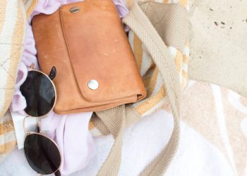 brown leather shoulder bag with dark sunglasses