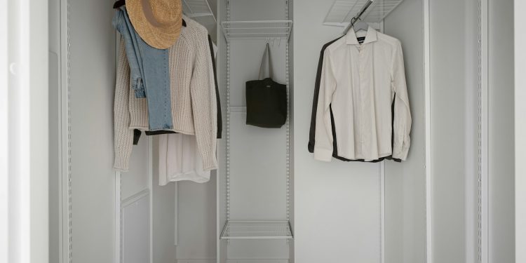A white closet with a hat and coat rack