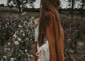 a woman standing in a field of flowers