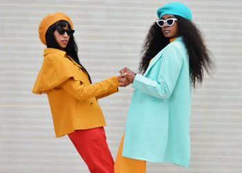 two women dressed in colorful clothing standing next to each other