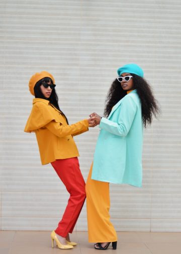 two women dressed in colorful clothing standing next to each other