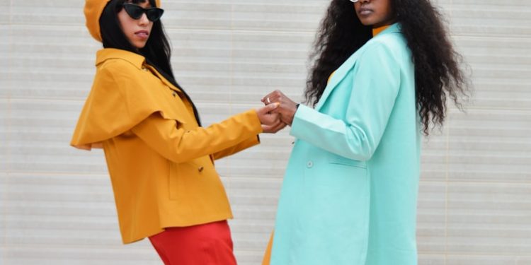 two women dressed in colorful clothing standing next to each other