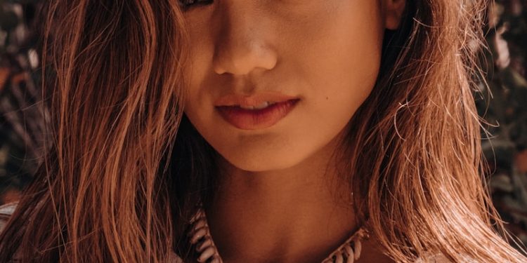 a woman wearing a necklace and a white shirt