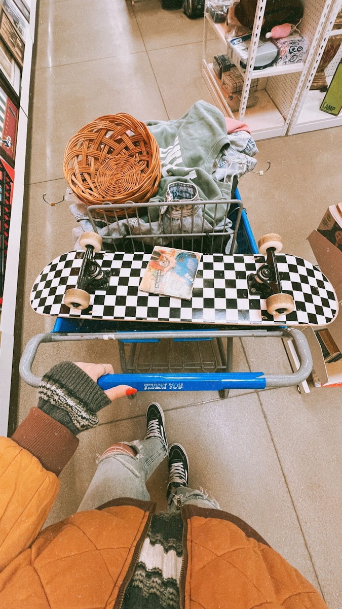 A person sitting on a shopping cart in a store