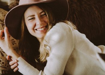 woman in white long sleeve shirt wearing black hat
