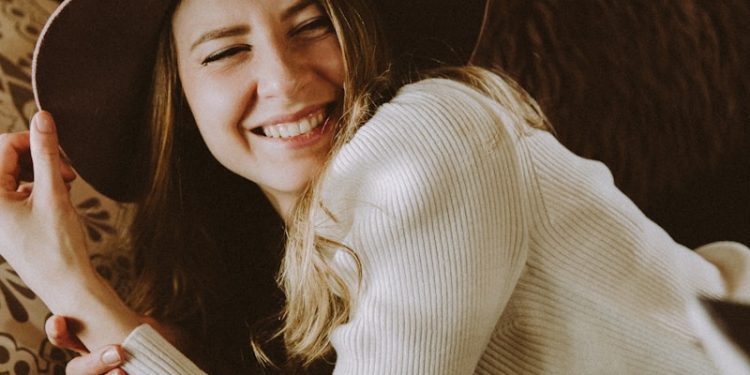 woman in white long sleeve shirt wearing black hat