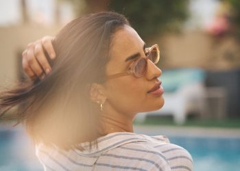 a woman standing next to a swimming pool