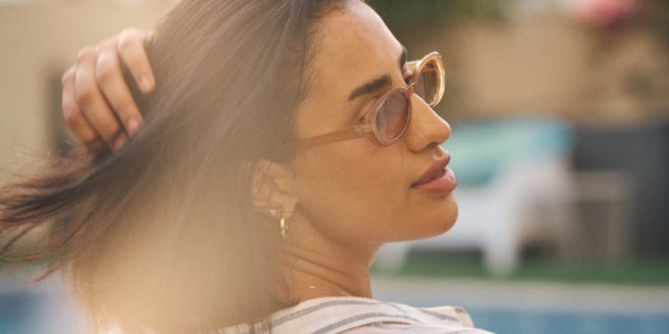 a woman standing next to a swimming pool